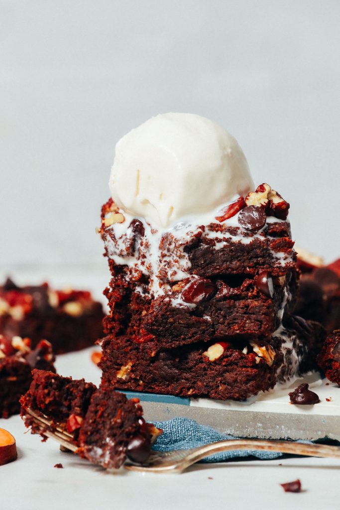 Vanilla ice cream melting down from a stack of Fudgy Sweet Potato Brownies